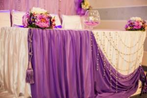 Decorating the edge of the wedding table with thick fabric