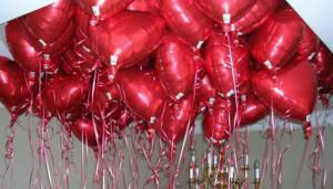 Foil red heart-shaped balloons hanging from the ceiling