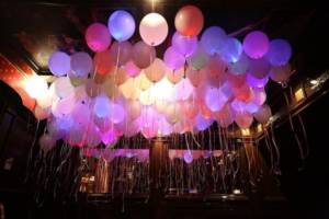 Креативно украсить гостиную можно светящимися шарами с гелием