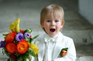 A boy reads a poem to the newlyweds at a wedding.