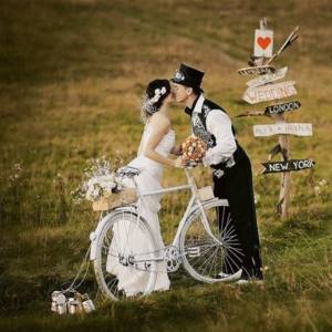 newlyweds with a bicycle in a field