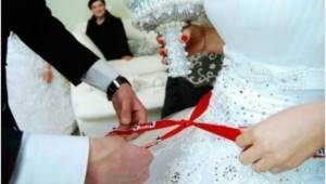 Tying a red ribbon to an Azerbaijani girl
