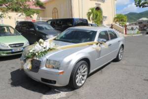 An example of a classic wedding car decoration made of flowers and ribbons