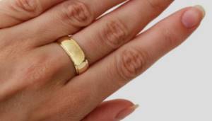 Wide convex gold ring on the hand
