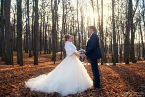 Wedding in November - bride and groom holding hands in the trees
