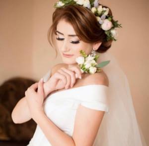 Wedding hairstyle with a wreath of fresh flowers