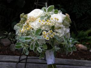 Decorating a bouquet with daisies with satin ribbon and beads