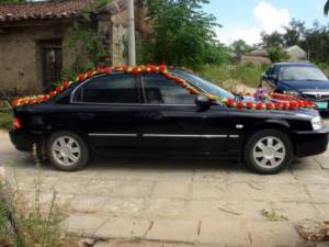 Decorating a car for a wedding with garlands of flowers