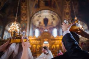 Wedding in St. Isaac&#39;s Cathedral in St. Petersburg. One of the duties of best men at an Orthodox wedding is to hold crowns over the newlyweds. 