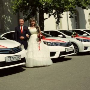 bride and groom near wedding cars